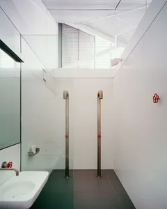 A modern bathroom with glass walls and a sink.