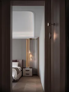 Modern bedroom with wood paneling and a hanging chandelier.