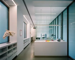 A modern laboratory interior with glass walls and white surfaces.