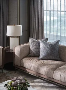 A modern living room featuring a plush, taupe-colored sofa adorned with geometric-patterned throw pillows, accompanied by a f