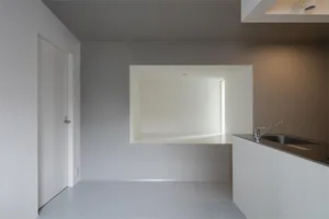 Modern white kitchen with minimalist design and white walls and flooring.