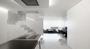 A modern living room with marble walls and a black table.