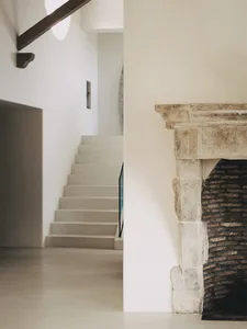 A minimalist concrete staircase with exposed beams in a modern interior.