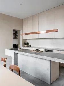Modern kitchen with concrete countertops and minimalist design elements.