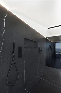Modern marble bathroom with sleek black fixtures and minimalistic design elements.