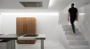 Modern minimalist kitchen featuring white marble steps and wooden cabinets.