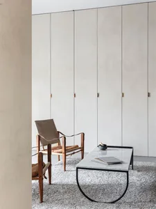 Modern minimalist living room featuring wood, leather, and marble accents.