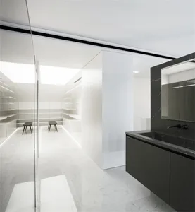 Modern minimalist bathroom with marble flooring and black accents.