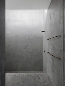 Minimalist bathroom with concrete walls and a simple, sleek design.