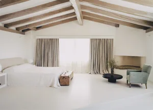 A minimalist bedroom with wood elements, soft lighting, and large windows.