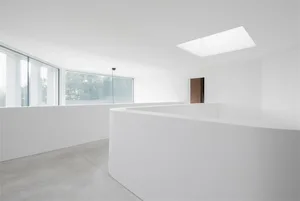 極簡室內空間，搭配混凝土牆面與大型玻璃窗。