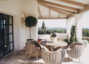 Outdoor seating area with wooden benches and potted plants overlooking hills