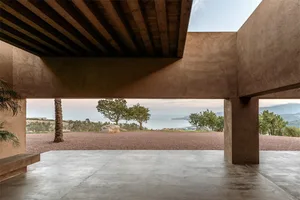 An open, minimalist patio with concrete flooring and a clear view of the natural surroundings.