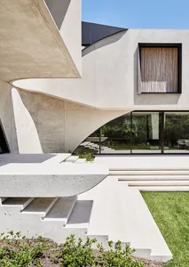 A modern house with a concrete exterior featuring clean lines and open spaces.