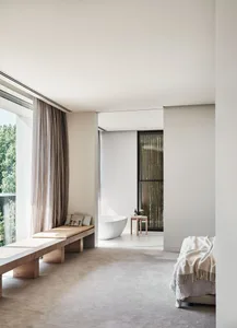 A modern minimalist bedroom featuring concrete and wood materials.
