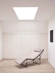A minimalist chaise lounger with white upholstery and a contemporary design.