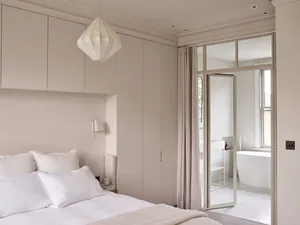 A minimalist bedroom with soft, neutral-colored decor and a clean, organized layout.
