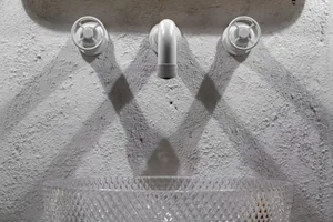 Concrete water faucet and sink in an industrial-style bathroom