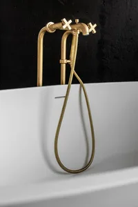 A minimalist bathroom with a metallic faucet and white tub.