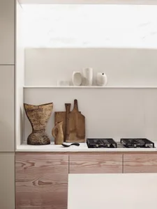 A minimalist kitchen featuring wooden cabinets and porcelain countertops.