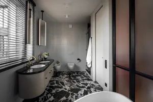 Modern bathroom featuring marble flooring and walls, contemporary fixtures, and a minimalist design.
