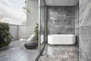Modern, minimalist bathroom featuring a freestanding bathtub and grey marble walls and floor.