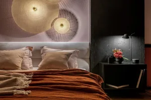 A cozy modern bedroom with a bed, pillows, and a blanket.