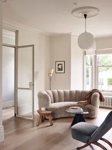 Modern, curved sofa with neutral fabric in a living room setting.