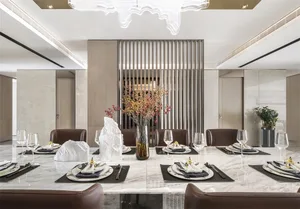 Modern dining room featuring marble table and chairs, with a centerpiece of dried flowers in a vase and place settings on the