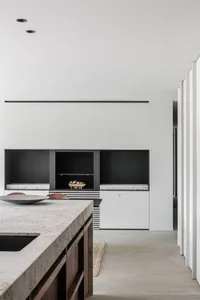 Modern kitchen featuring a concrete countertop and marble sink, with a minimalist design.