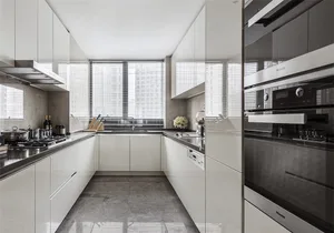 Modern kitchen with white cabinets, stainless steel appliances, and a window with blinds.