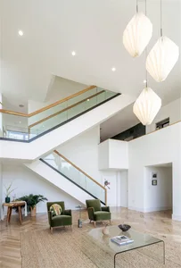 A modern living room features glass, metal, and wood materials.