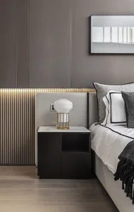 Modern minimalist bedroom featuring a marble top nightstand, wooden floor, and metal accents