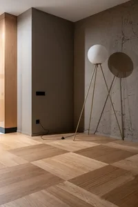 Minimalist interior design featuring a wooden floor with geometric patterns, illuminated by a modern floor lamp against a tex