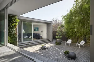 A modern patio featuring wooden furniture and landscaping
