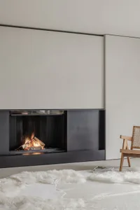 Minimalist fireplace with a black metal frame emitting flames.