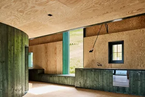 Modern residential space featuring minimalist design with wooden elements and large windows.