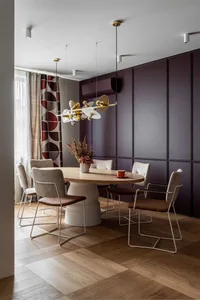 Modern dining room featuring a wooden table with black and white chairs, geometric patterned curtains, and a hanging chandeli