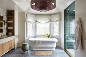 Modern bathroom with a freestanding bathtub, marble flooring, glass shower enclosure, and minimalist design.