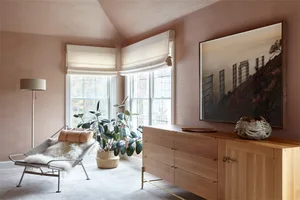 A modern living room featuring wooden furniture, fabric seating, and potted plants.