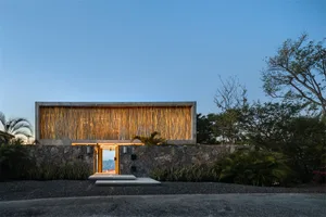A minimalist residential exterior featuring concrete and natural lighting.
