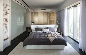 Modern bedroom with a white bed, brown metal headboard, and natural fiber bedding.