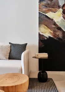 Modern interior design showcasing a black side table with a minimalist aesthetic, featuring a stack of books and a textured r