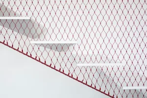 Minimalist design showing concrete stairs with metal netting and red netting on a white background.