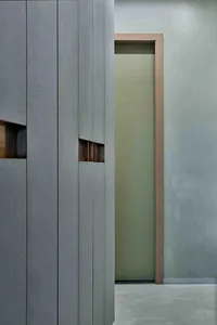 A modern room divider with textured panels and a minimalistic design, featuring doors with windows for light diffusion.