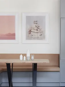 Modern kitchen featuring a cushioned bench, minimalist design with a natural wood table and metal legs.