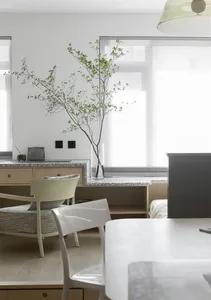A modern minimalist kitchen featuring a terrazzo countertop and light-colored furniture.