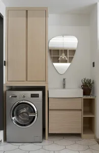 Modern minimalist laundry room with wooden paneling, a sink, and a washer.