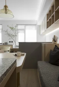 A modern minimalist kitchen with marble countertops and glass cabinets.