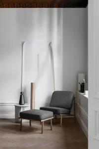 Minimalist living room with a grey fabric sofa on a wooden floor.